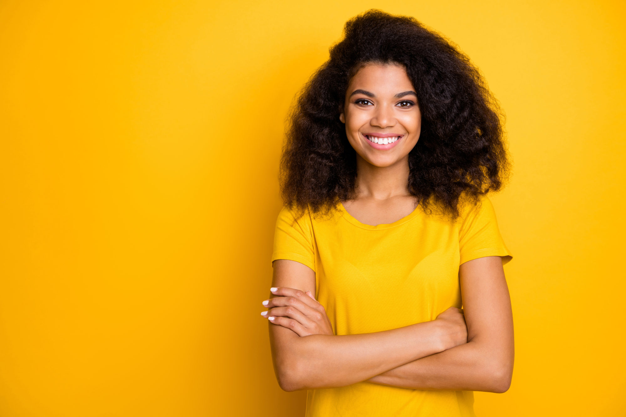 Close-up portrait of her she nice attractive lovely pretty content cheerful cheery wavy-haired girl folded arms isolated over bright vivid shine vibrant yellow color background brooklyn orthodontics
