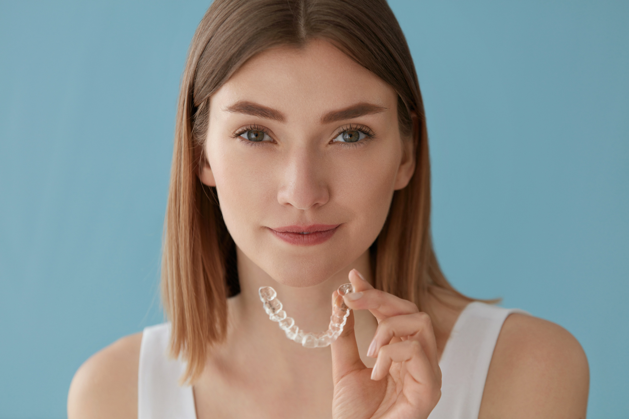 Teeth whitening. Woman with healthy teeth using removable braces brooklyn orthodontist